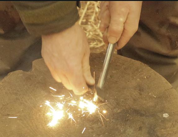 Bushcraft. Hands lighting fire on stone