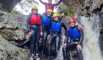 Group of people stopping for a pic under the bloody bridge waterfall