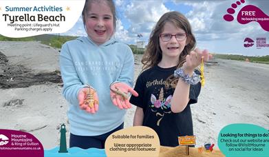 Two girls holding lizards at the beach