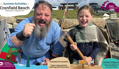 A viking and a child enjoying summer activities at Cranfield Beach.