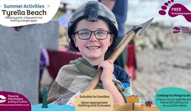 A boy dressed as a viking enjoying beach activities
