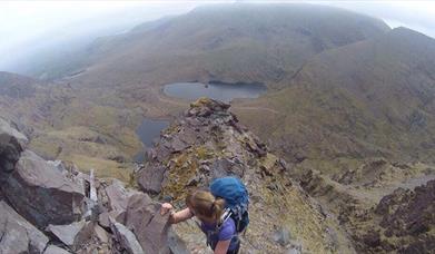 Hiker climbing in Mourne Mountains
