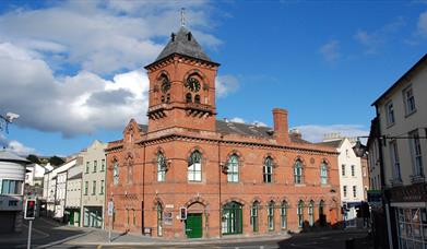 Red brick exterior with town hall clock of Down Arts Centre that sits at the junction of Irish Street, English Street and Scotch Street. 