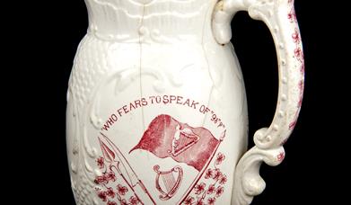 A jug printed with the phrase 'who fears to speak of '98?'  in red, which was made to commemorate the centenary of the 1798 rebellion.