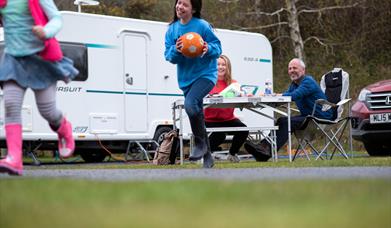 Family of four enjoying at snack outside their caravan