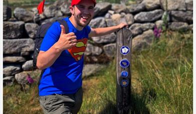 Nathan posing at the way mark sign