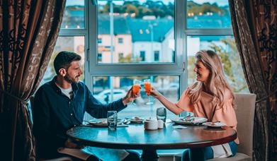 Couple enjoying food and drink at Canal Court Hotel over looking Newry Canal