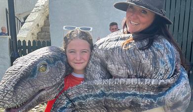 A dino being cuddled in a sling