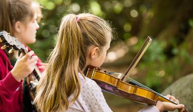 Homegrown Harmonies, two girls playing instruments. A Celebration of Traditional Music & Culture
