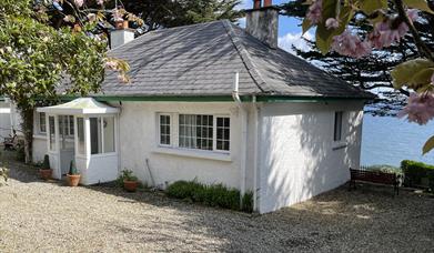 Reception room showing open tread stairs to the attic bedroom, sofa and armchairs.
