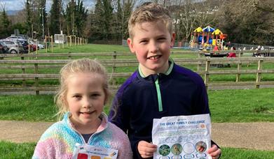 Two children standing together with their worksheet enjoying the Forest Activities programme in Kilbroney Park, Rostrevor.