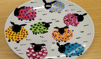Plate with sheep painted onto it.