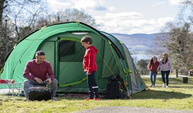 Family enjoying a BBQ infront of their tent in Kilbroney Park