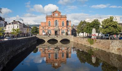 Picture of Newry Town Hall with a reflection of the hall in the Clanrye River infront.