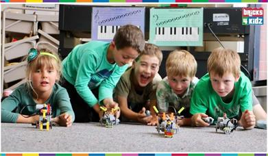 a group of boys playing with Lego Technic vehicles