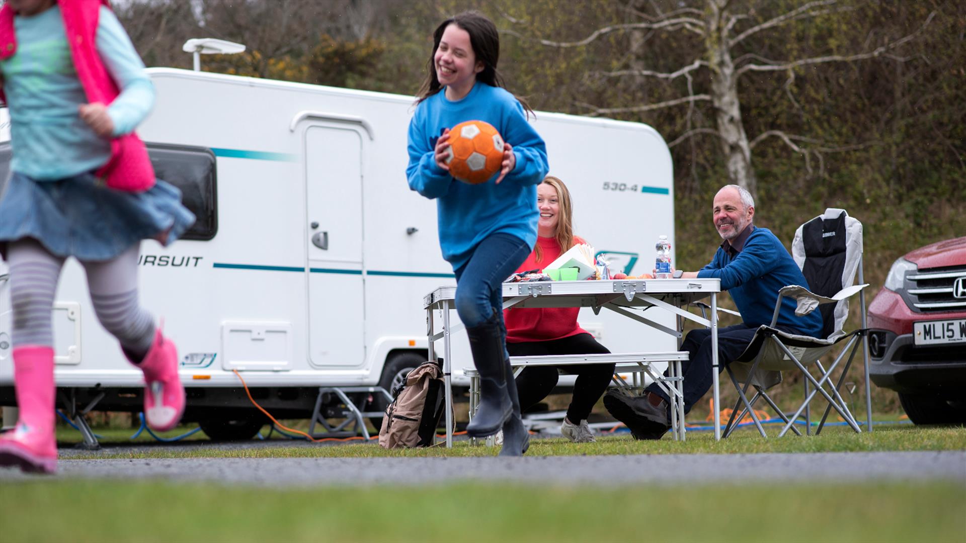 Family of four enjoying at snack outside their caravan