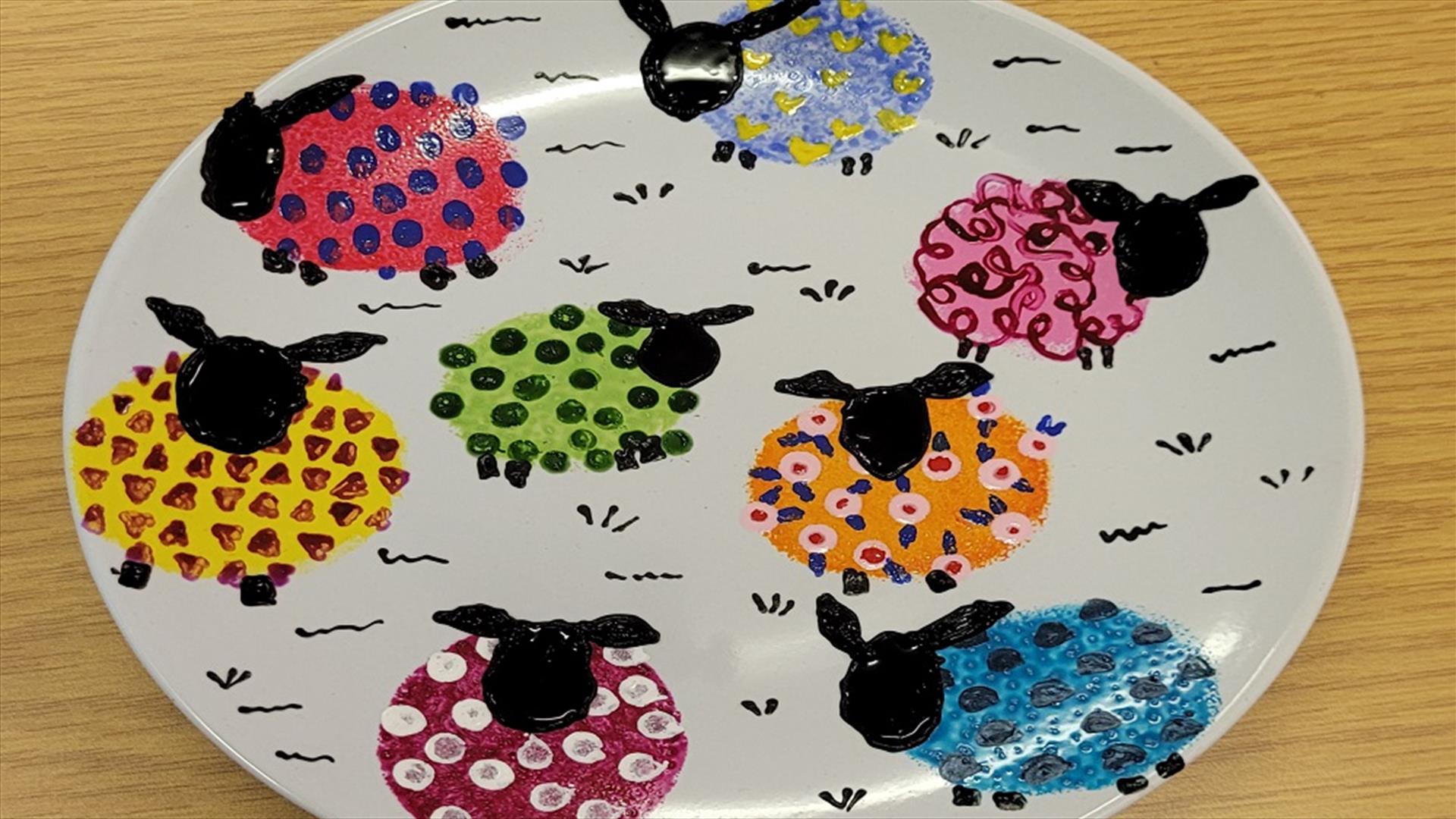 Plate with sheep painted onto it.