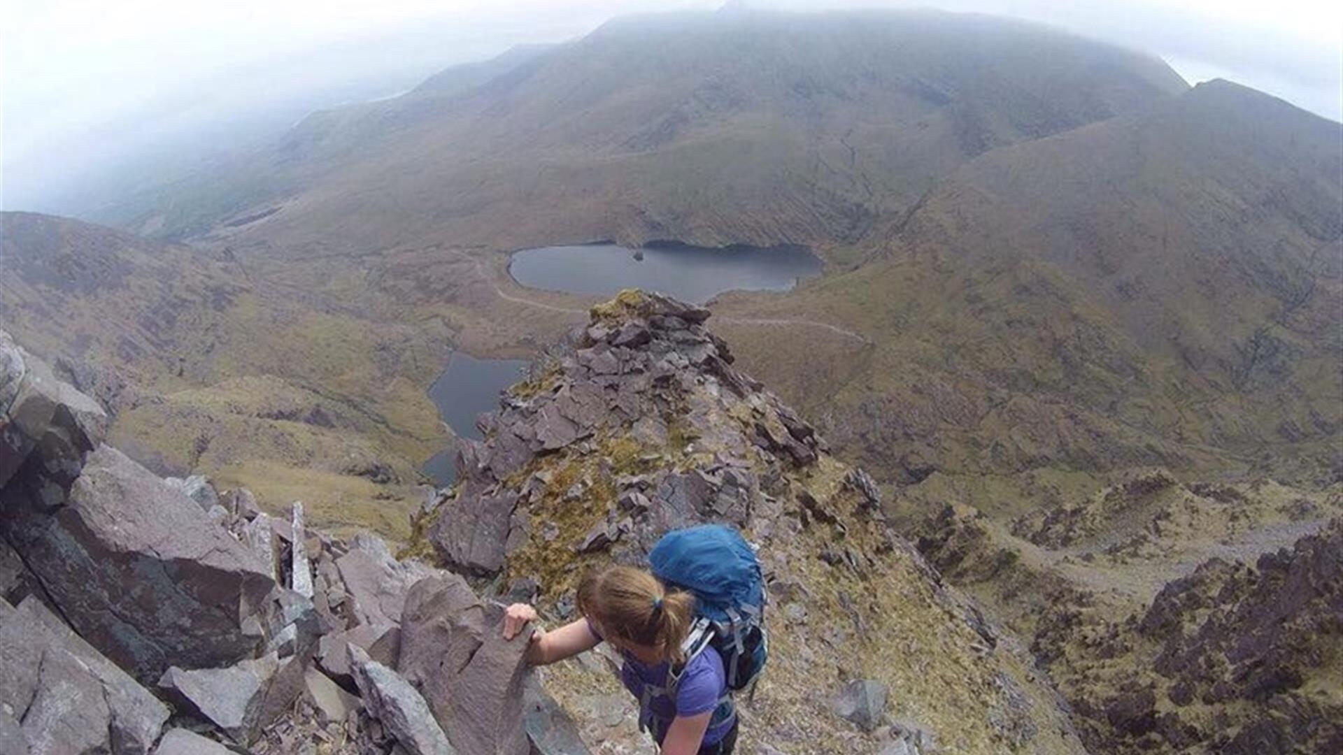 Hiker climbing in Mourne Mountains