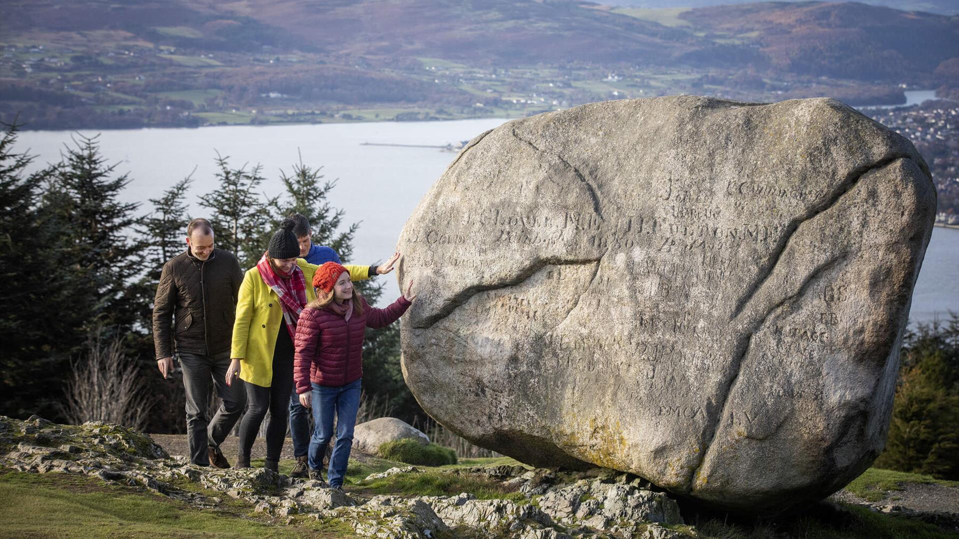 Images depicts a family at the Cloughmore Stone in Rostrevor. © Tourism Ireland photographed by Brian Morrison