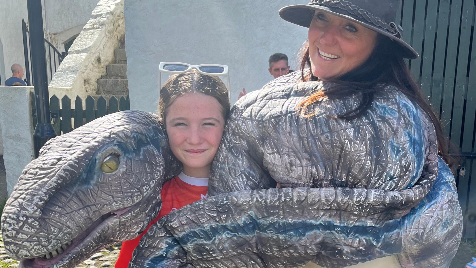 A dino being cuddled in a sling