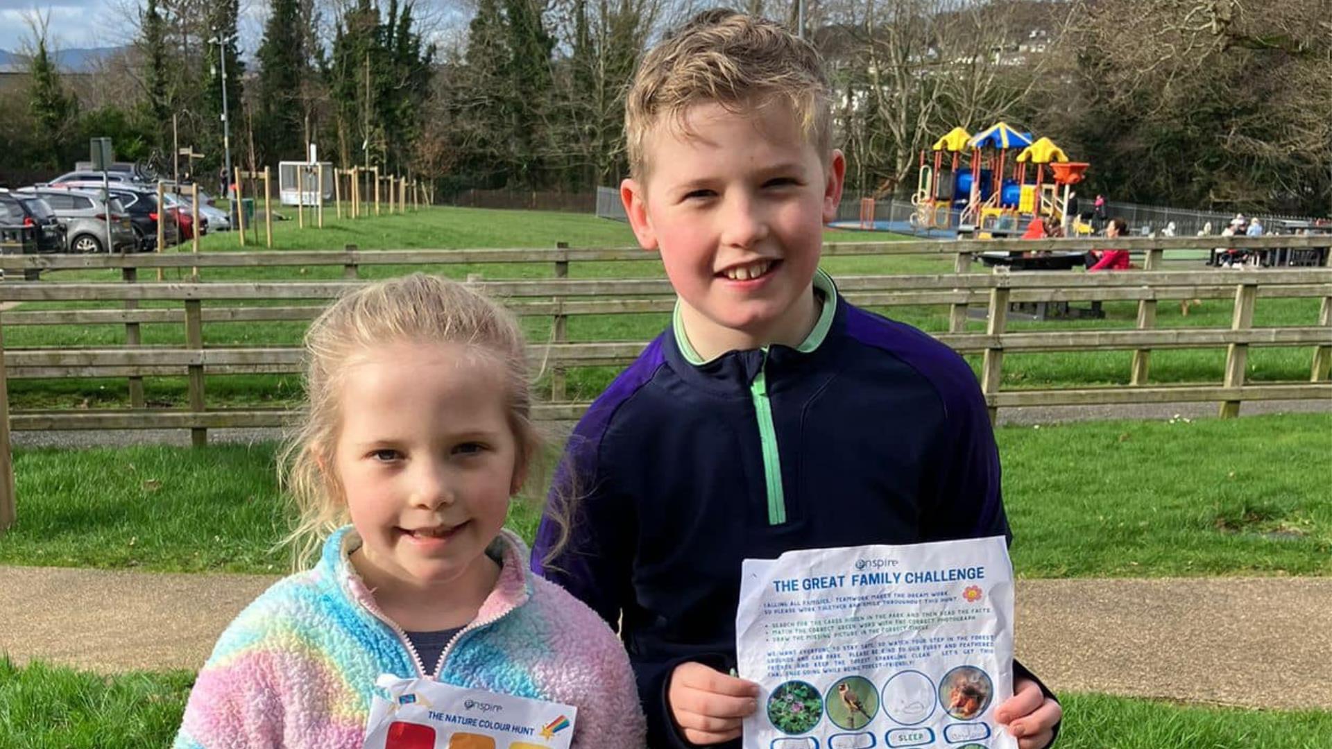 Two children standing together with their worksheet enjoying the Forest Activities programme in Kilbroney Park, Rostrevor.
