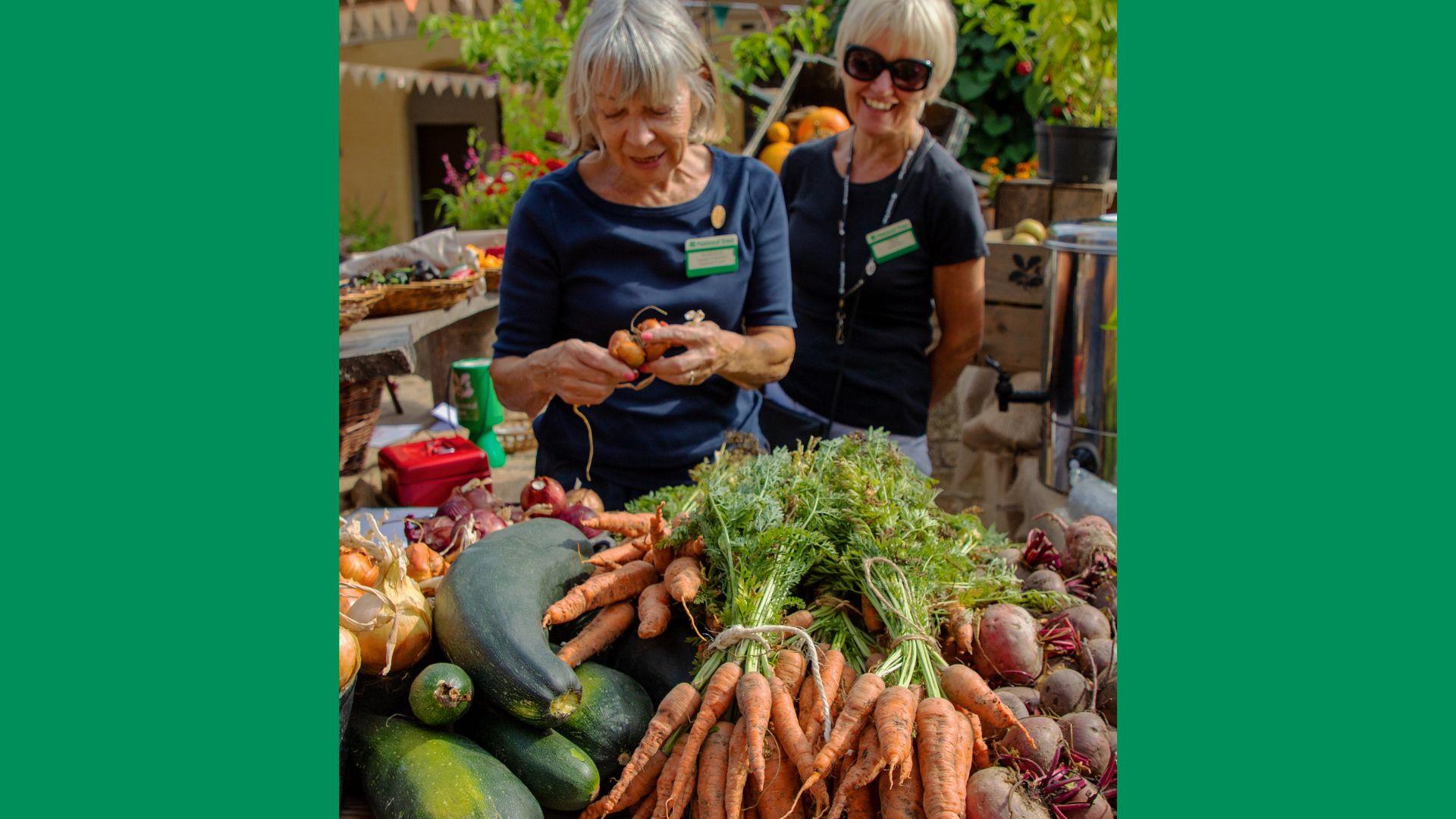 Two Trust Volunteers with locally grown produce