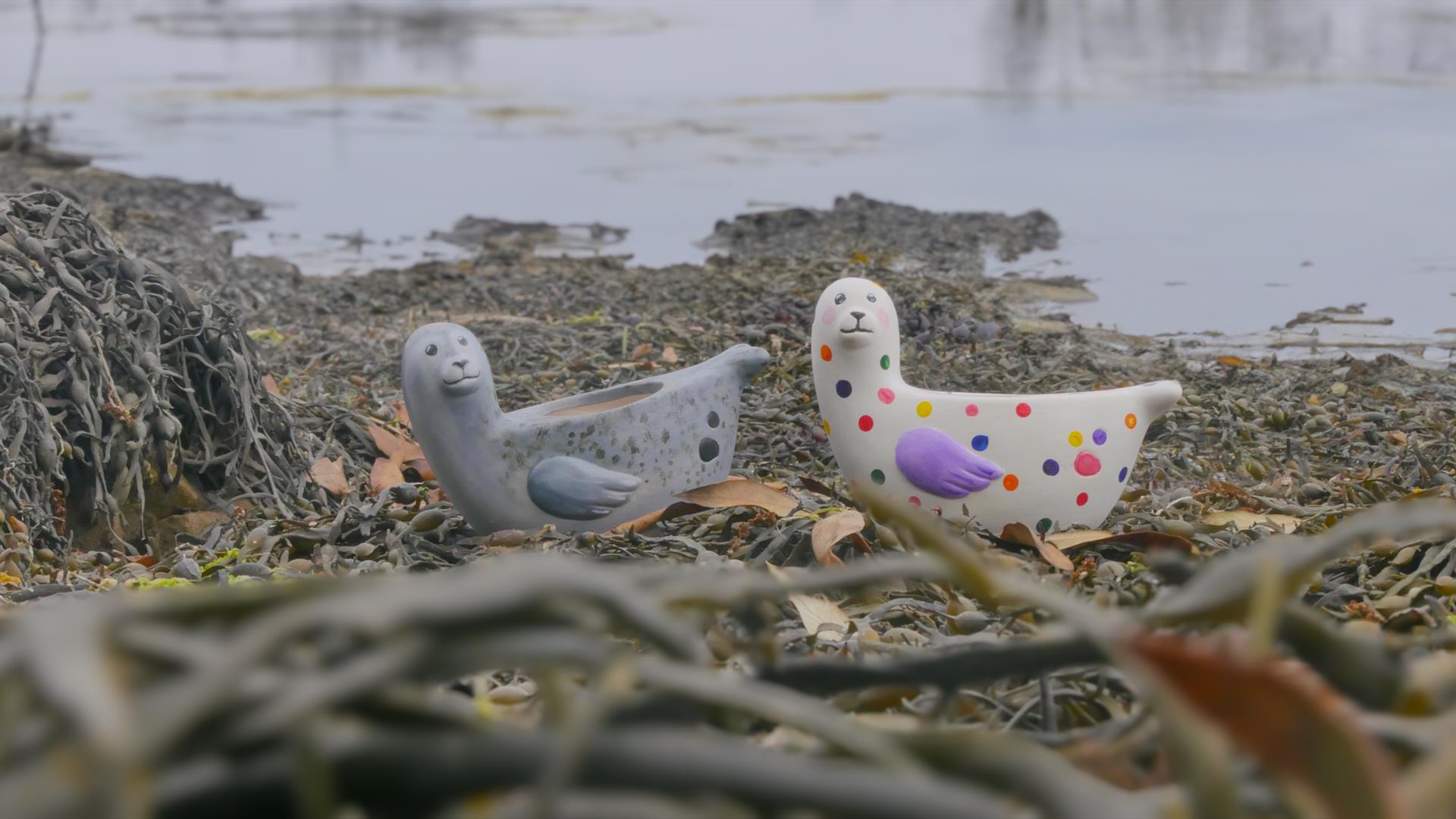 Two painted ceramic seals on the bay