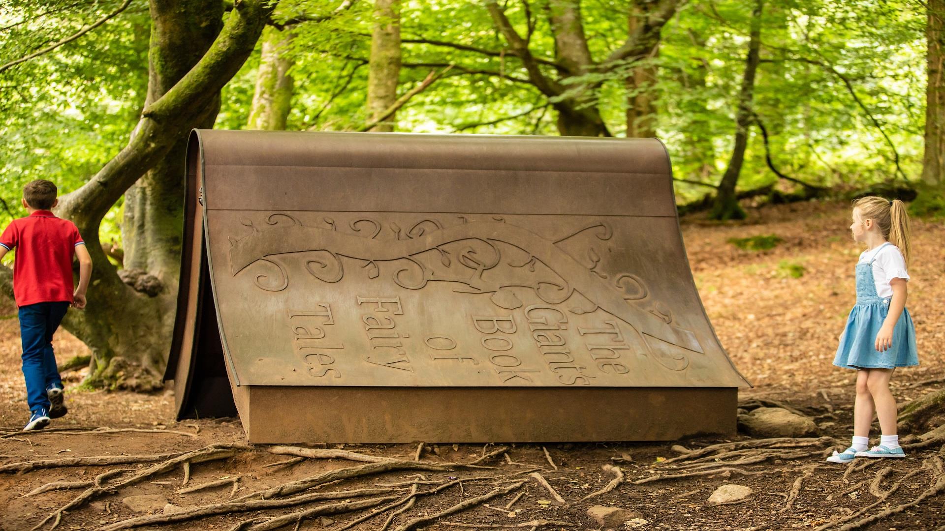 Children playing around a giant book in Slieve Gullion Forest Park