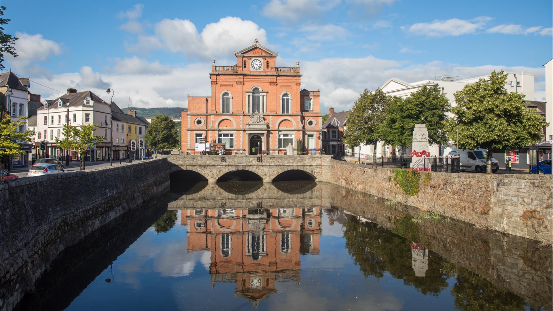 Picture of Newry Town Hall with a reflection of the hall in the Clanrye River infront.