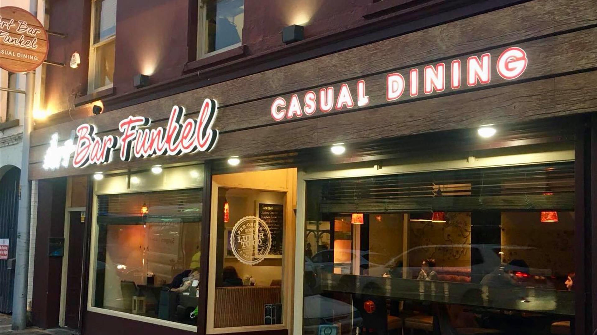 picture showing the front of resturantlit up at night time.