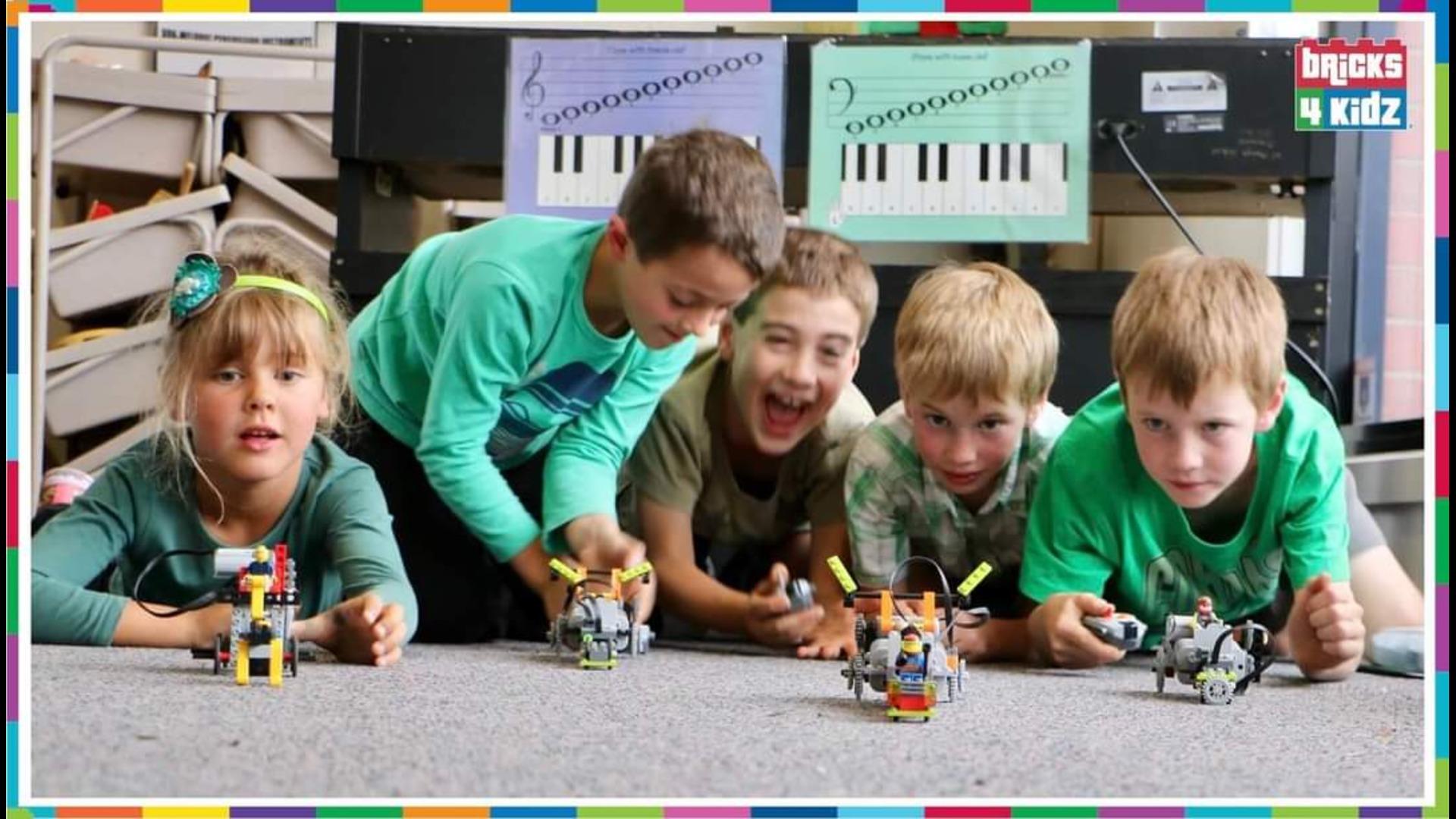 a group of boys playing with Lego Technic vehicles
