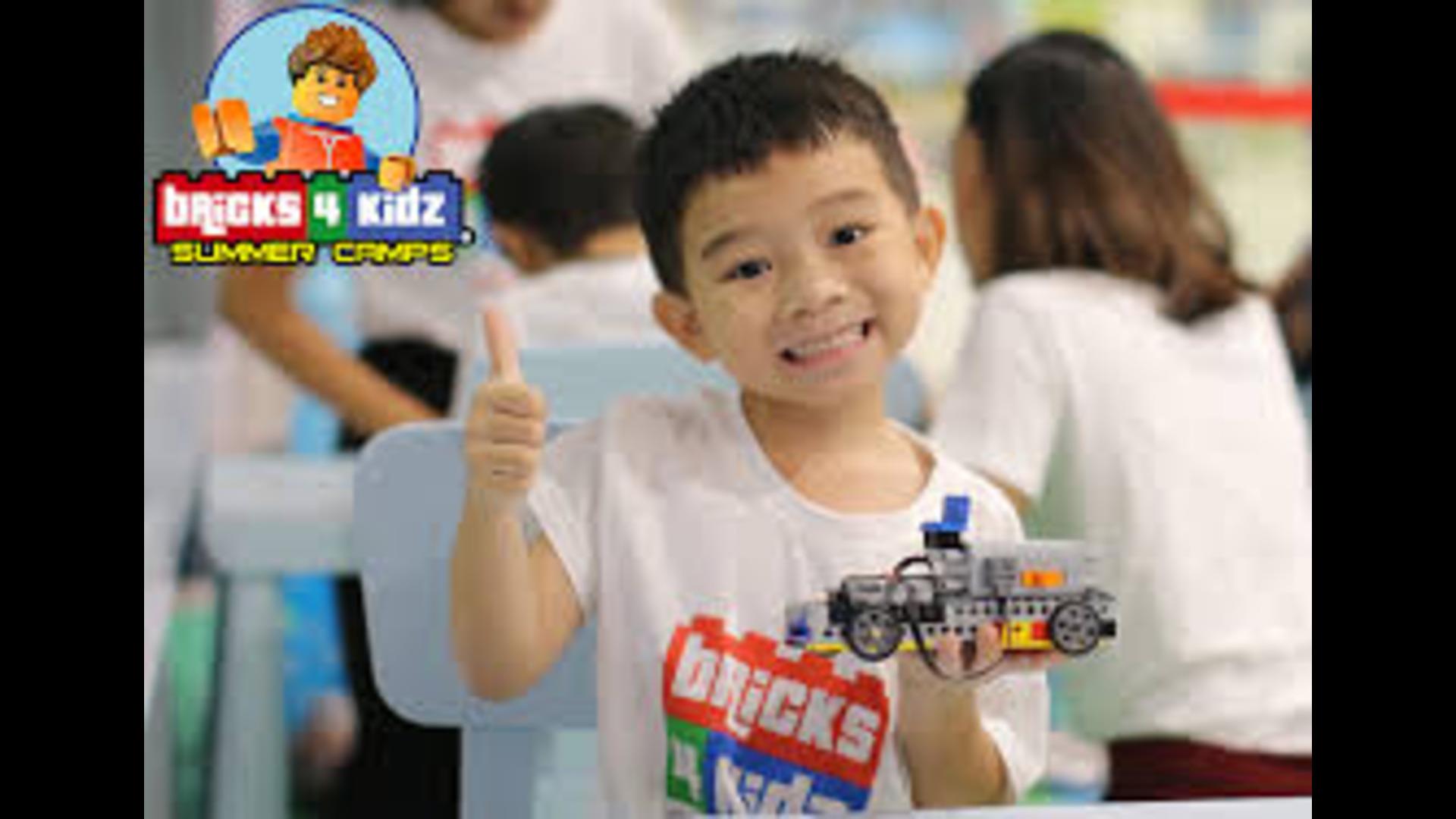 A child enjoying a lego workshop with his thumb up