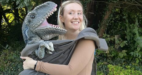 A dino being cuddled in a sling