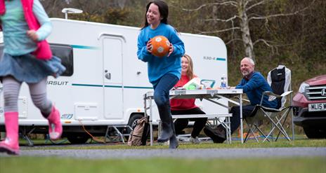 Family of four enjoying at snack outside their caravan