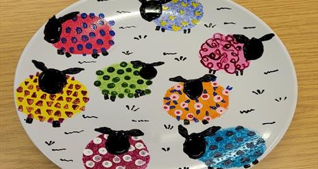 Plate with sheep painted onto it.
