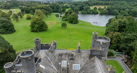 Aerial shot of Castlewellan Historic Demesne taken above the castle, with the Mourne Mountains in the distance.