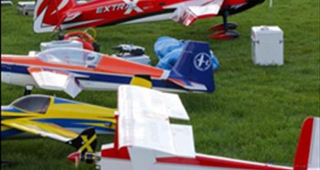 Model aeroplanes sitting on the grass ready to fly.