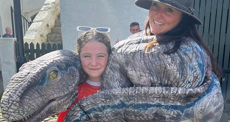 A dino being cuddled in a sling