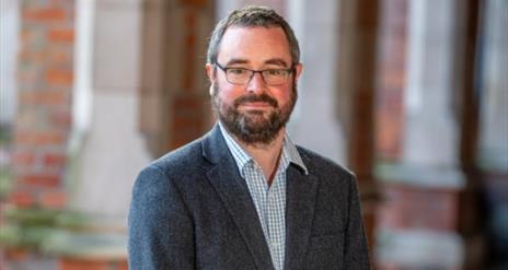 Portrait photo of the speaker, Dr Andrew Holmes.