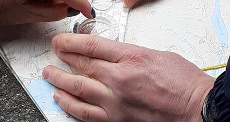 Compass being used to locate ourselves on the mountain