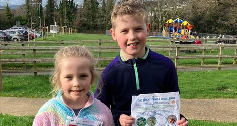 Two children standing together with their worksheet enjoying the Forest Activities programme in Kilbroney Park, Rostrevor.