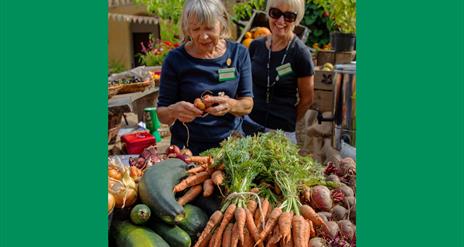 Two Trust Volunteers with locally grown produce