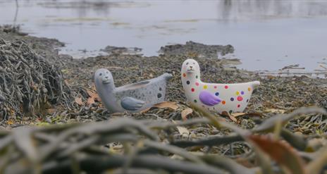 Two painted ceramic seals on the bay