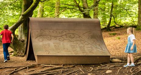 Children playing around a giant book in Slieve Gullion Forest Park