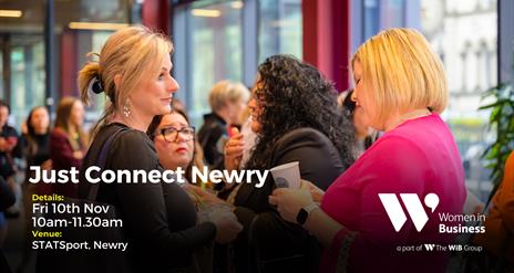 Two women are chatting in a room filled with other women