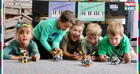 a group of boys playing with Lego Technic vehicles