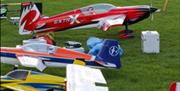 Model aeroplanes sitting on the grass ready to fly.