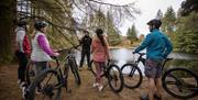 Cyclists standing at the lake with their Bike Mourne leader.