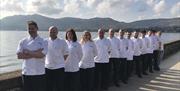 A image showing the staff from The Whistledown Hotel lined along the front shore opposite The Whistledown Hotel.