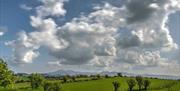 White clouds in blue sky with view to Mourne Mountains